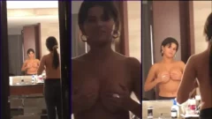 María Goicoechea sosteniendo sus grandes pechos con expresión seductora