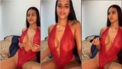 Kelly Oliveira, una mujer de cabello oscuro, usando ropa íntima provocativa mientras se estimula con un juguete sexual